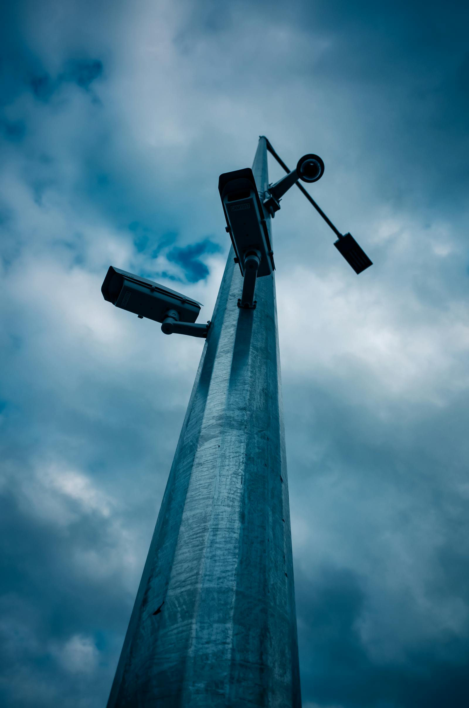 A low-angle shot of a cluster of CCTV cameras mounted on a pole. The same techniques that find a missing person can be used to dox someone — the discipline gives real leverage, how you use it is on you. Photo by Sonny Sixteen on Pexels.